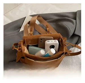 Internal capacity of brown suede crossbody bag showing phone and cosmetics storage