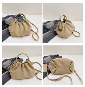Detail view of beige suede bucket bag showing the metal ring handle and reinforced base