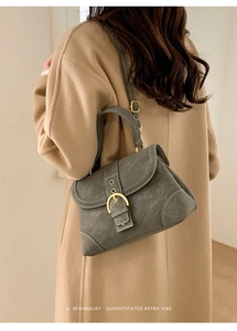 Detail of retro small square bag with matte leather texture and gold horseshoe buckle