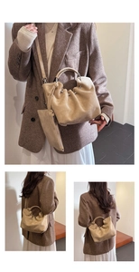 Detail of khaki pleated bucket bag featuring round metal handles and matching coin purse