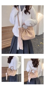 Detail view of beige suede cloud bag featuring metal ring handle and adjustable strap
