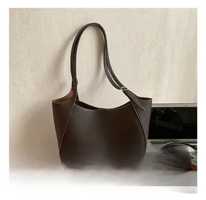 Dettaglio borsa sottobraccio in pelle marrone scuro con cuciture bianche a contrasto