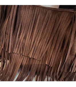 Macro detail of deep brown suede-texture fringe layers on a vintage tote bag