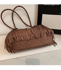 Close-up of brown suede bag featuring dense long fringe and slim shoulder straps