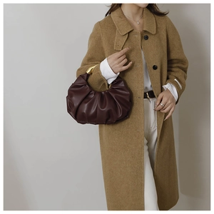 Détail du sac croissant plissé marron rouge avec une poignée métallique dorée courbée