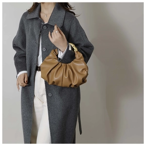 Détail du sac croissant plissé caramel avec poignée élégante en métal doré