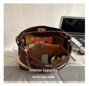Detail of spacious interior compartments in a brown quilted bucket bag with tablet and gadgets