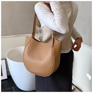 Dettaglio della borsa hobo in pelle color cammello con trama a grana indossata a spalla
