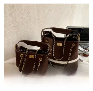 Detail showing two sizes of brown suede bags with plush trim and gold chain straps