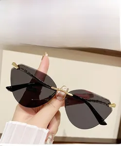 Detail view of cat eye sunglasses with grey lenses and gold metal nose bridge