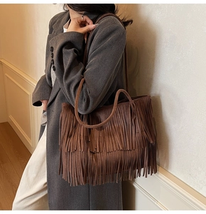 Dettaglio della borsa tote in pelle scamosciata marrone scuro con frange e manico tondo