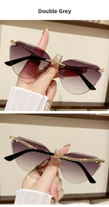 Detail of rimless cat eye sunglasses with double grey lenses and gold metal top bar frame