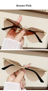 Detailed macro of rimless cat eye sunglasses with brown pink gradient and gold snake legs