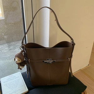 Detail of dark brown pebble leather bucket bag with silver lock and bear pendant