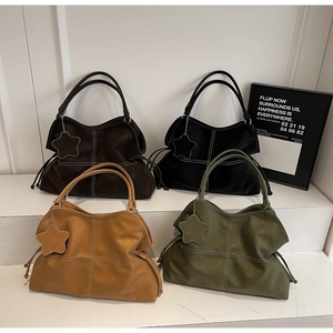 Detail of four retro tote bags in various colors featuring contrast stitching and star charms