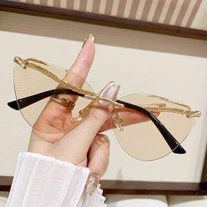 Frameless cat-eye sunglasses with brown tinted lenses and gold textured metal temples