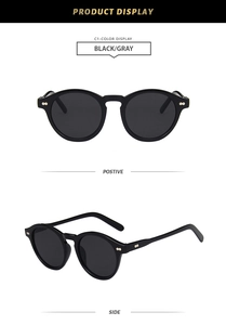 Detail view of vintage round sunglasses with black frames and gold rivets on both temples
