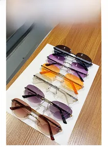 Detailed top view showing six colors of ultra-light rimless oval sunglasses on a display