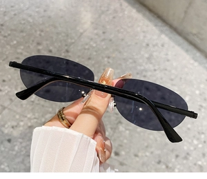 Close-up of lightweight oval rimless sunglasses with gradient lenses and slim temples