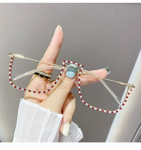 Detailed macro view of half-frame glasses with red and white crystal embellishments