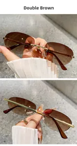 Detail view of double brown gradient lenses and gold metal temples on rimless sunglasses