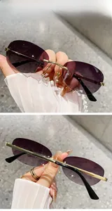 Detail of retro rimless oval sunglasses with double grey gradient lenses and gold bridge
