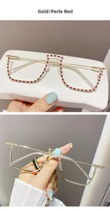 Macro detail of gold half-frame glasses with red and white pearls and sparkling rhinestones