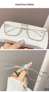Detail of half-frame gold glasses with pearl embellishments and transparent lenses