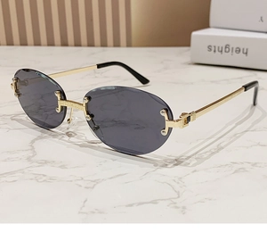 Detail view of gold metal bridge and grey rimless oval lenses with refined textures