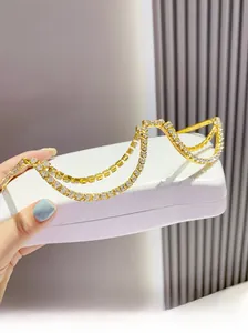 Detail of gold metal half-frame glasses with double-layered sparkling rhinestone chains