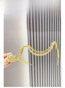 Close-up of wavy gold-tone rimless glasses frame with sparkling white rhinestones
