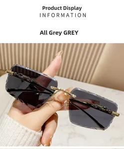 Close-up of rimless grey sunglasses with gold metal leopard decoration and geometric edges