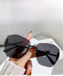 Detail of grey gradient rimless oversized sunglasses with geometric cutout lenses