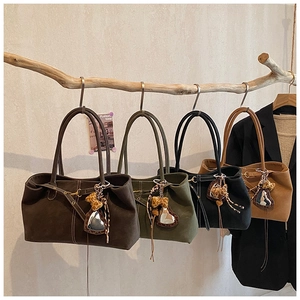 Detail of multi-colored matte leather tote bags hanging on branch with leopard charms