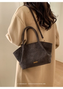Detailed view of deep brown tote bag featuring golden hardware and retro matte texture