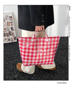 Detail of red and white checkered waterproof tote bag featuring bold white text and top handles
