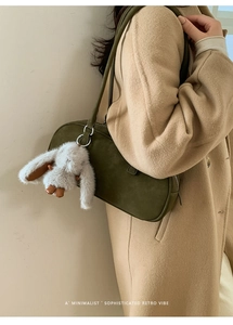 Olive green leather Boston bag detail with plush rabbit charm and silver metal buckle