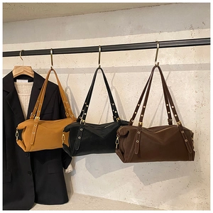 Detailed view of vintage tote bags in brown and black with gold rivets and smooth fabric