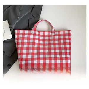 Detail of red and white checkered canvas tote bag with bold TOTE BAG lettering print