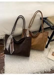 Detail view of large matte tote bags in dark brown and caramel with silk scarf accents