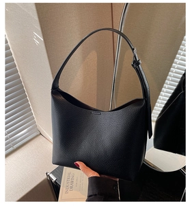 Detail of black lychee grain leather hobo bag with adjustable silver metal buckle strap