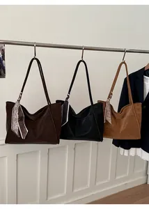 Detailed view of large tote bags in coffee, black and camel with decorative scarves