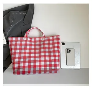 Detail view of red gingham plaid tote bag with spacious capacity and woven texture