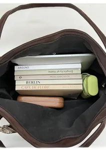 Close-up of the spacious interior of this brown suede tote bag with a laptop and books