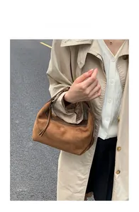 Dettaglio borsa hobo in pelle scamosciata marrone con cerniera a frange e design a mezzaluna