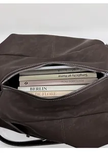 Detail view of large brown leather tote bag interior showing ample capacity for books