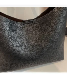 Close-up of black pebble grain leather texture on the bucket bag with fine stitching