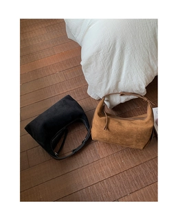 Detail view of stylish matte suede dumpling bags in black and caramel brown colors