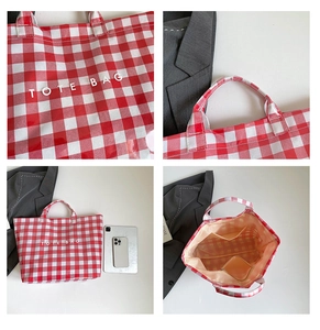 Detail of red checkered tote bag with inner compartments and waterproof canvas texture