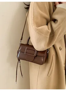 Detail of vintage brown leather handbag with large buckle and knot strap detail